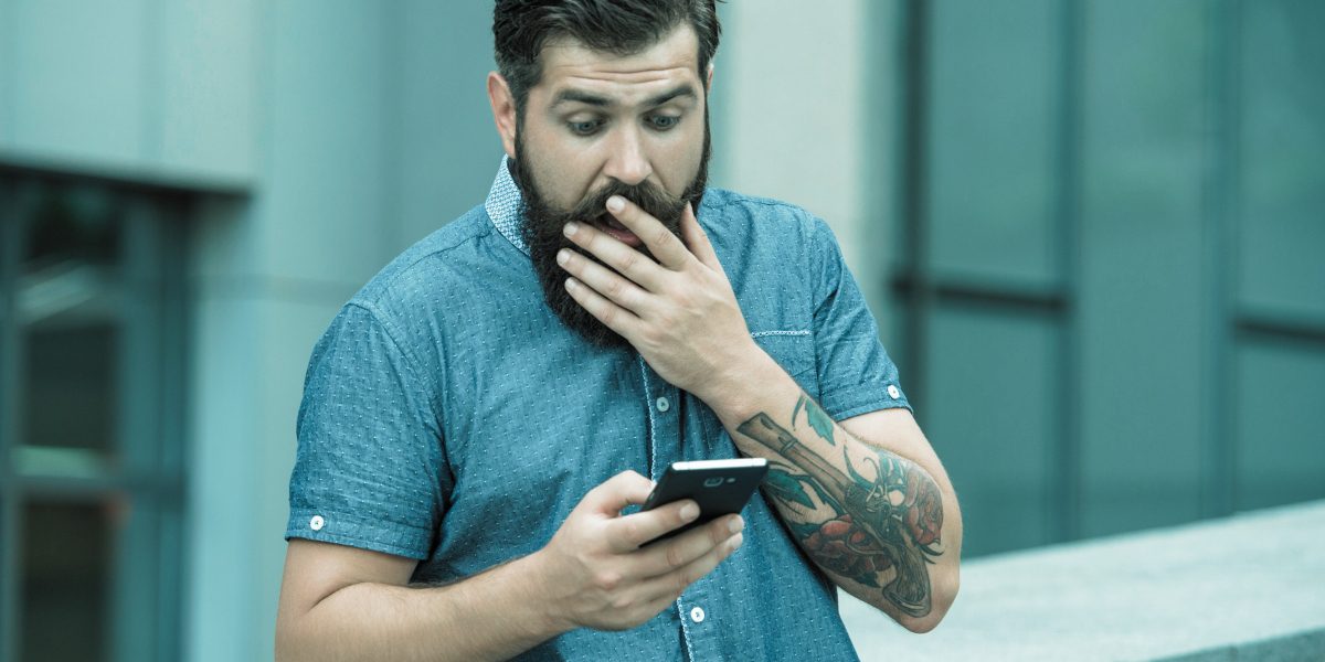 homme qui lit les conditions du bonus de bienvenue sur son smartphone - le bon parieur