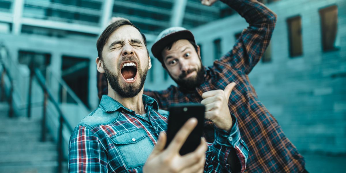 deux amis qui célèbrent leur victoire d'un pari sportif grâce au bonus genybet - le bon parieur