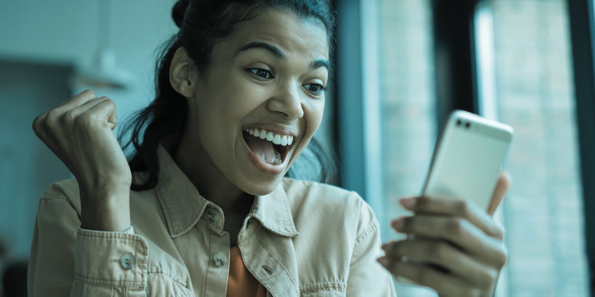 femme contente de parier en ligne sur son bookmaker préféré - le bon parieur