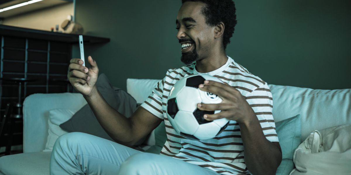 homme heureux de naviguer sur son application de paris sportif - le bon parieur